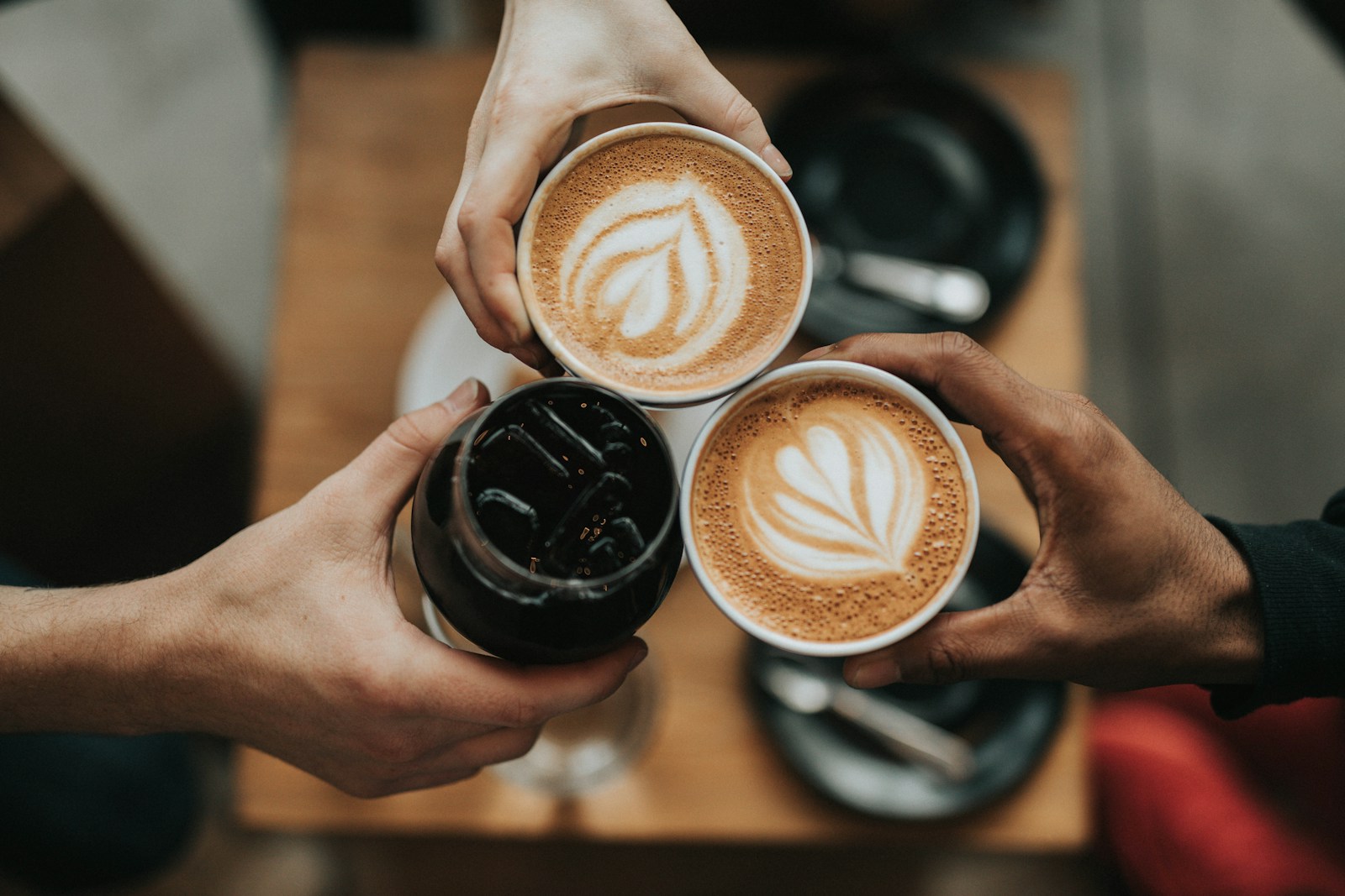 A small countertop espresso machine pulling a fresh shot into a glass shot pitcher, golden crema on the surface.