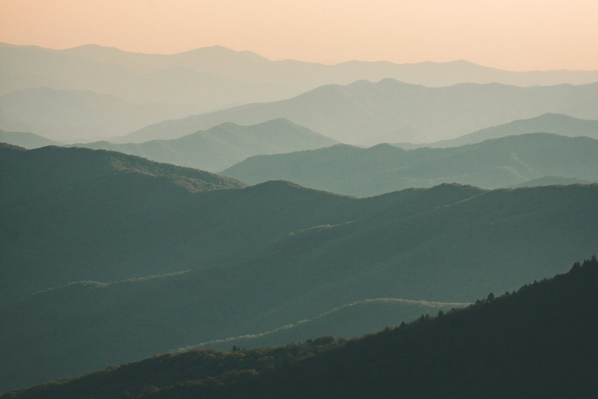 Layered blue ridges of the Great Smoky Mountains fading into haze, seen from a high overlook in soft morning light.
