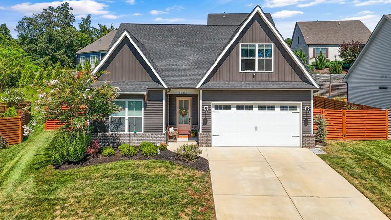 A gray board-and-batten craftsman home with a two-car garage and landscaped front yard in a newer West Knoxville subdivision near Turkey Creek.