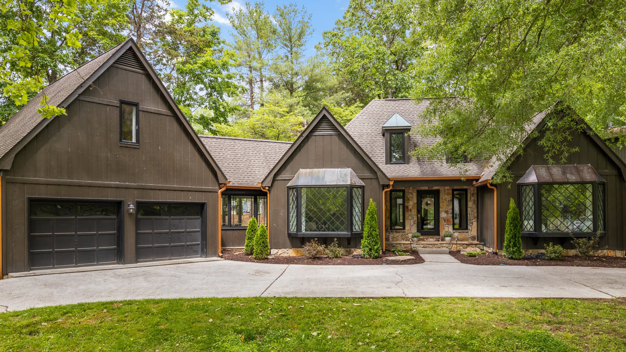 A bright, neutral kitchen with white cabinets, light hardwood floors, and a vase of fresh greenery on the island — the kind of move-in ready space that sells fast.
