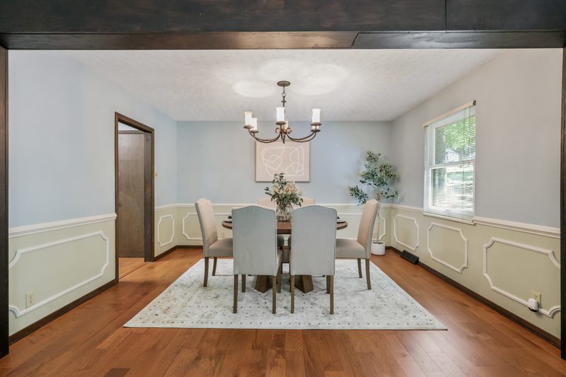 Formal dining room with chandelier, wainscoting and hardwood floors